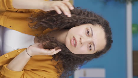 Vertical-video-of-Young-woman-looking-at-camera-with-curious-expression.